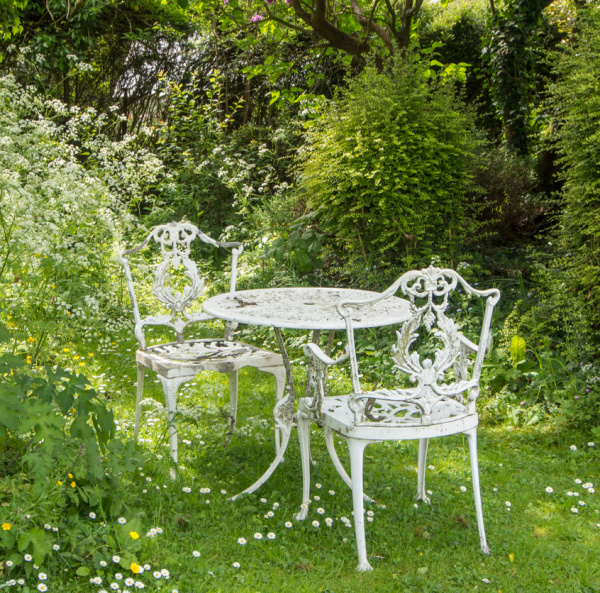 White iron furniture in a spring garden