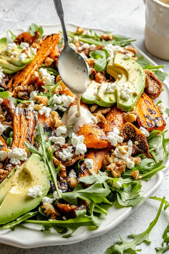 Beautiful carrot arugula salad with sweet dried figs, tangy goat cheese, creamy avocado and crunchy walnuts. 