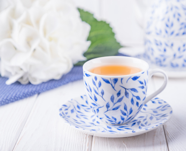 white hydragneas and a blue and white cup of tea.
