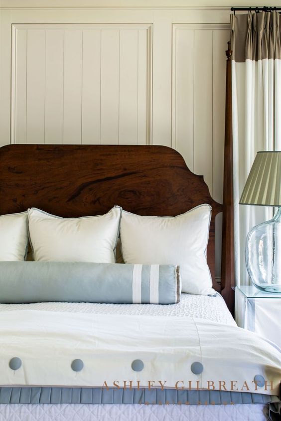 Ashley Gilbreath bedroom with ivory comforter and blue and white bolster.