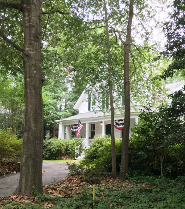 white cottage with an American flag and bunting.