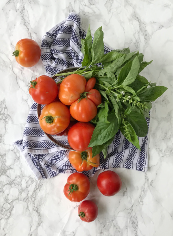 vine ripe tomatoes and herbs and a blue and white towel