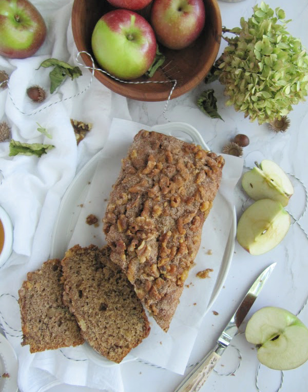 applesauce bread sliced with apples in a bowl and hydrangeas.