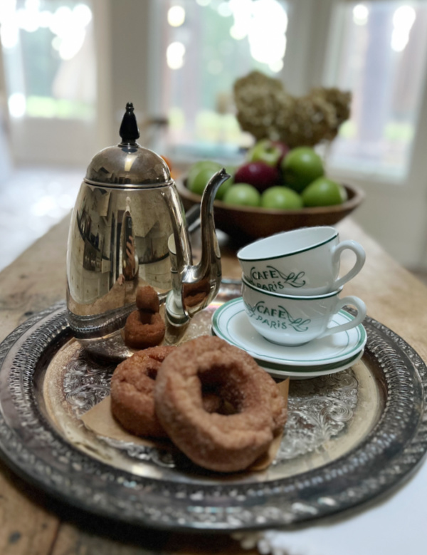 pumpkin donuts and hot chocolate in a silver pot.