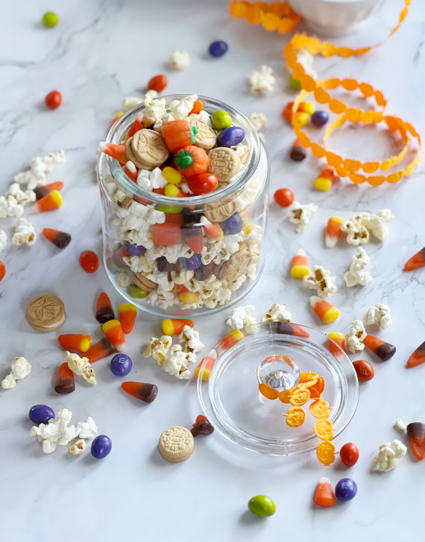 5 minute 5 ingredients fall snack mix in a clear glass jar and orange ribbon.