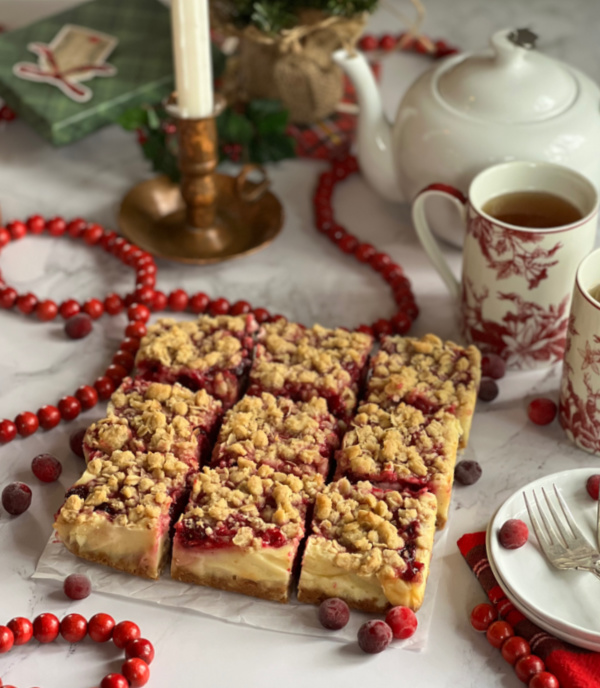 Sliced cranberry bars and a pot of tea snd two cups.