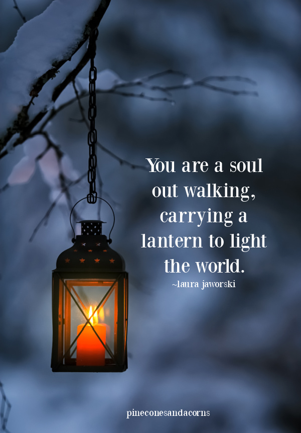 laura jaworski you are a soul carrying a lantern to light the world text overlay on a lantern hanging in a tree in the winter.