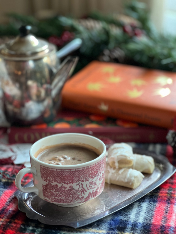 Cup of hot chocolate cookies and 2 winter cook books including Comfort_ A Winter Cook Book.
