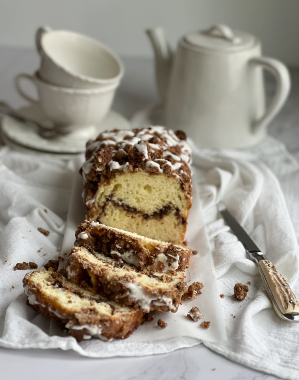 Cinnamon swirl quick bread with 2 cups and a tea pot. 