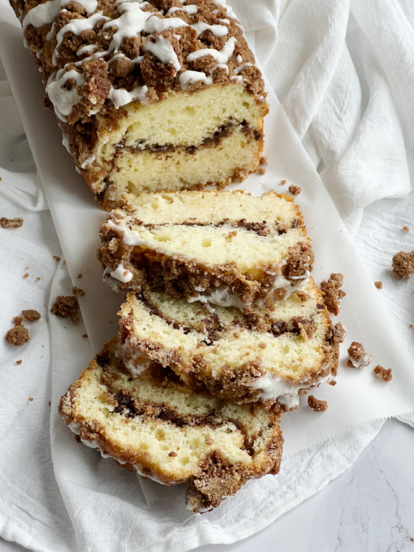 Cinnamon swirl quick bread with streusel topping on a white tea towel.