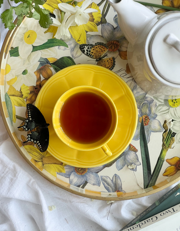 Yellow and white tray with daffodil flowers and a yellow tea cup and saucer.