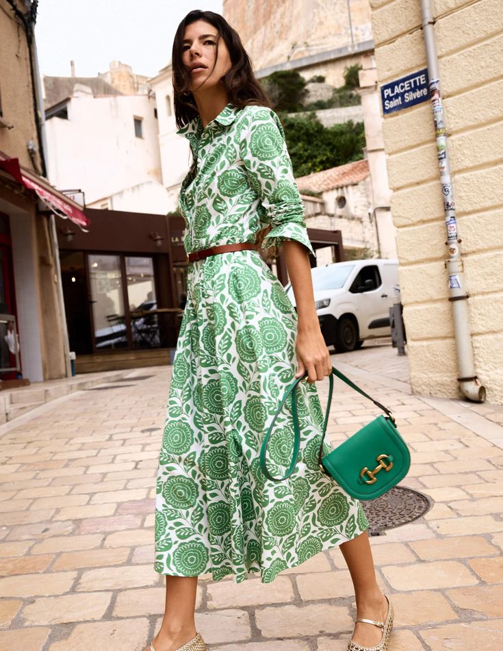 Woman wearing a Green and white midi dress.