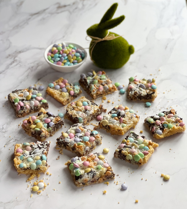 Magic Cookie Bars and a bowl of M&M and a green rabbit with a tan bow. 