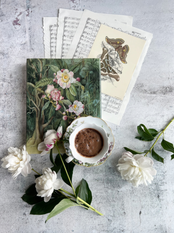 Flatlay with music white peonies a cup of chocolate and a book