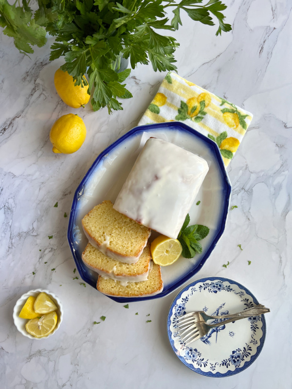 Ina Garten Lemon Yogurt Loaf Cake with frosting on a platter sliced.