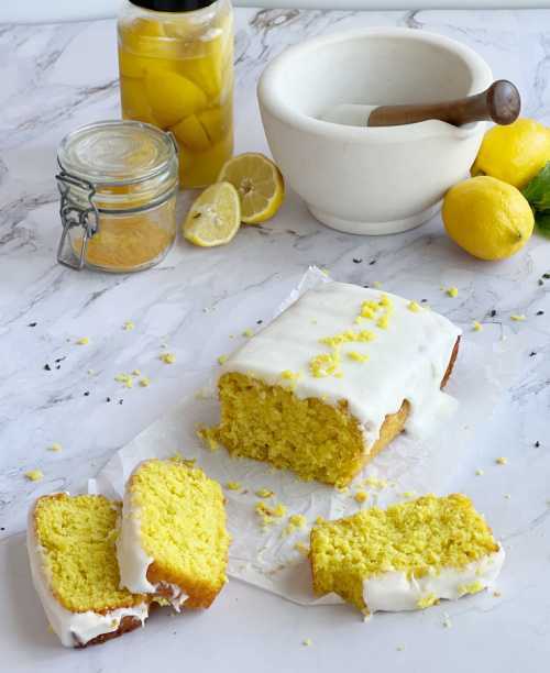 Lemon loaf cake with a mortar and pestle and fresh lemons.