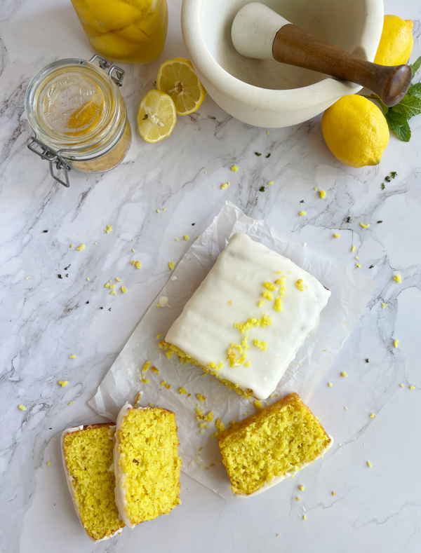 Preserved lemon loaf cake, a marble mortar and pestle and lemons.
