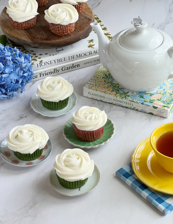 banana cupcakes with honey buttercream icing a white teapot, yellow cup and books.