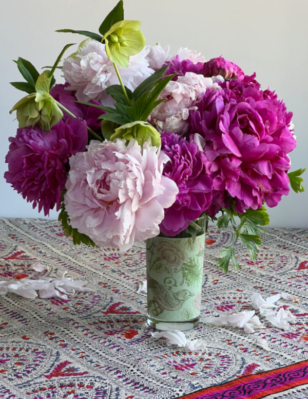 fuchsia and pink peonies in a green glass with a bird.