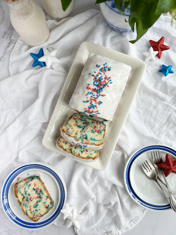 4th of July Funfetti pound cake red white blue sprinkles sliced on blue and white plates.