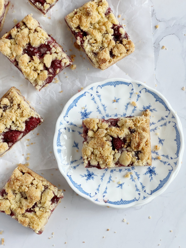 sliced raspberry bars on a blue and white transfer ware plate.