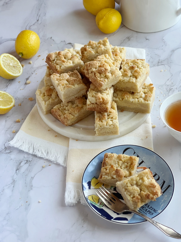 lemon crumb bars piled high on a round plate
