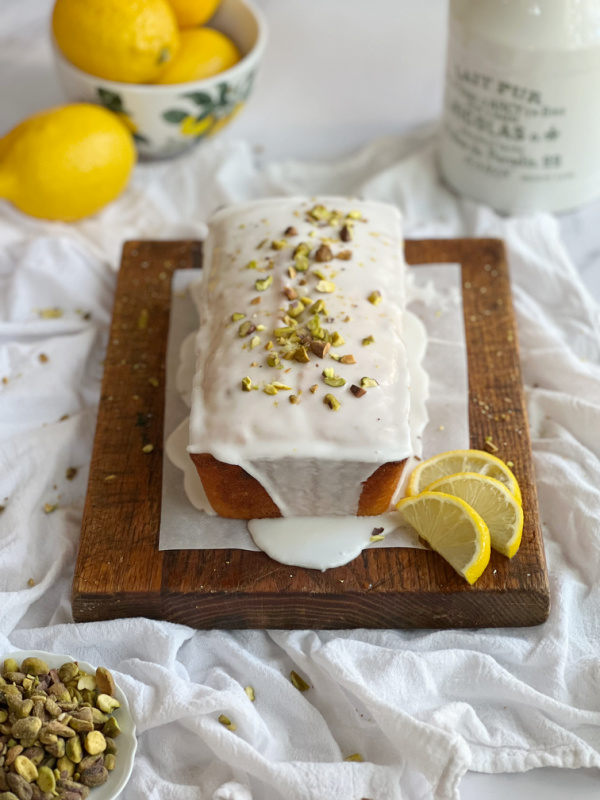 lemon pistachio bread with a bowl of lemons in a bowl.