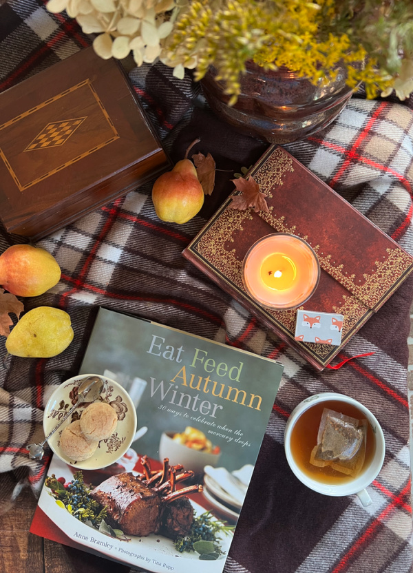 Fall Flatlay with pears, a candle, cookbook and a cup of tea.