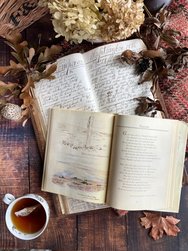 September Flatlay with tea, books, basket, bird.