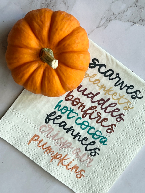 orange pumpkin and a napkin with a list of fall bucket list items.