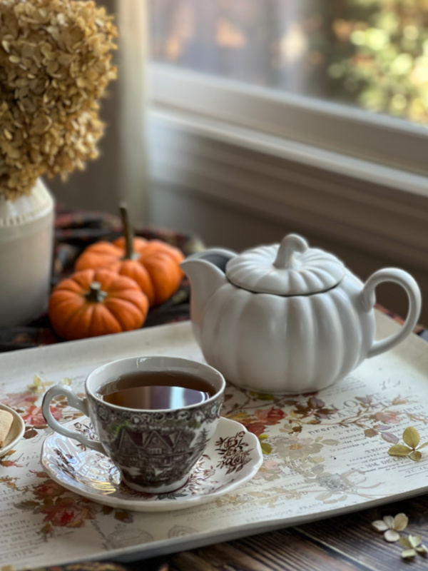 pumpkin tea pot and a cup of tea on a tray.
