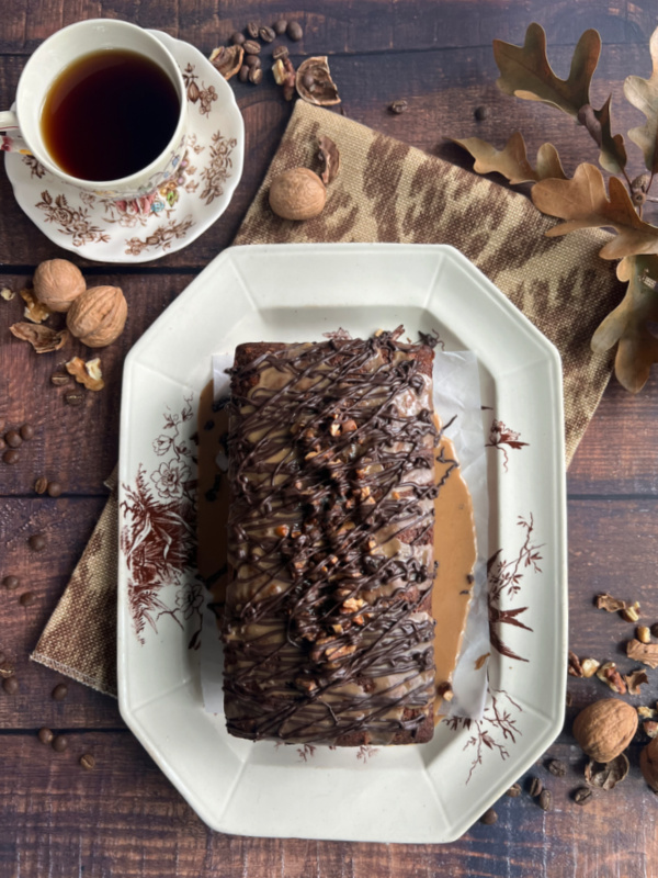 Date Walnut Coffee Cake with Espresso Glaze on aa brown and white plate.