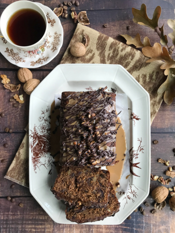 sliced date bread on a brown and white platter with a cup of tea.