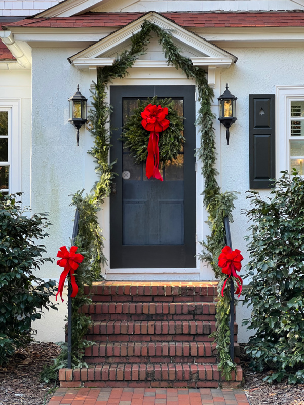 White House with black door and festive holiday decorations.