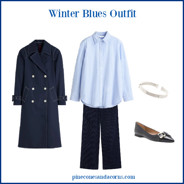 Fashion over 50 winter blues outfit with trench, shirt, silver bracelet, blue ballet plates with silver buckle and a blue pair of pants.
